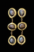 Boucles d'oreilles longues dorées avec trois perles baroques sur fond noir